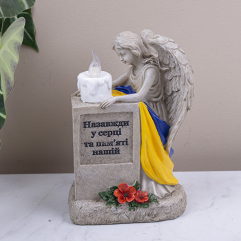 фігура на кладовище ангел з прапором та підсвіткою на сонячній панелі